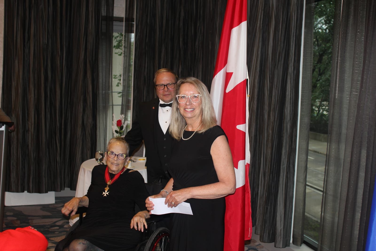 Dame Carolyn Taylor-Smith and Chevalier Chuck Hamel presenting a cheque to Reverend Debbie Fawcett, guest speaker from the Mustard Seed